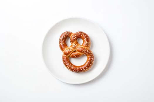 Single Soft Pretzel with Sesame Seeds on White Plate photo