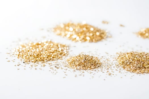 Gold glitter scattered on white background photo
