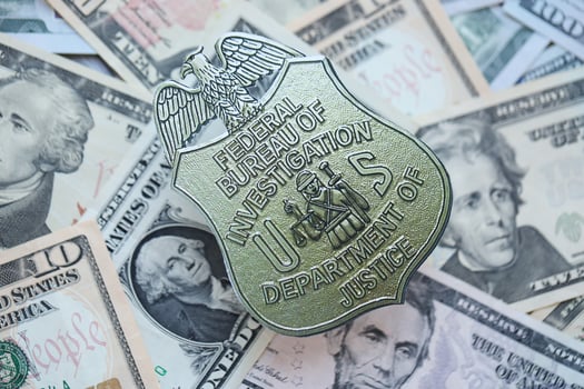 KYIV, UKRAINE - MARCH 9, 2024 US FBI Federal Bureau of Investigation badge on many US dollar bills photo