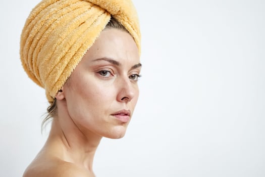 Woman with towel wrapped around her head looking at the camera photo