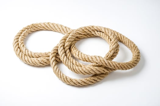 Close-up of thick rope on white background photo