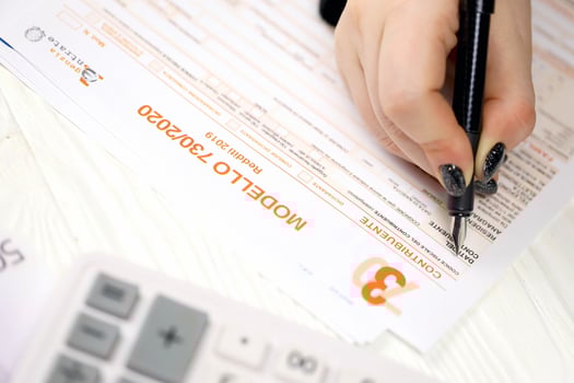 KYIV, UKRAINE - OCTOBER 31, 2023 Accountant fill italian tax form Modello 730 individual income tax return in end of tax period. Taxation and paperwork routine photo