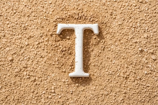 White Letter T on Brown Gravel photo