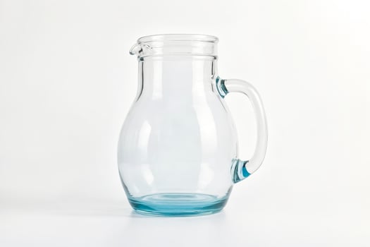 Empty Glass Pitcher with Blue Rim on White Background photo