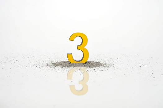 Yellow Number 3 in a Pile of Sand photo