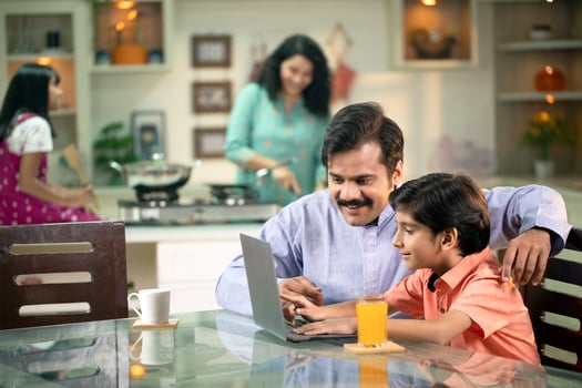 Father Helping Son By Studying Online Using A Laptop photo