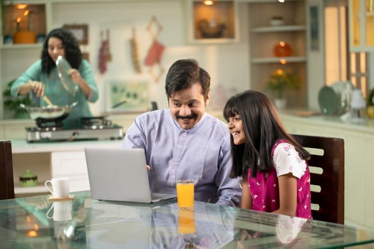 Father Daughter Surfing Internet With Laptop On Table At Kitchen photo