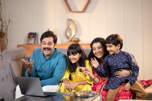 Blissful Family In Front Of Laptop Smiling And Waving Hands photo
