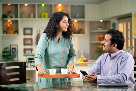 Charming Wife Serving Tea To Her Husband photo