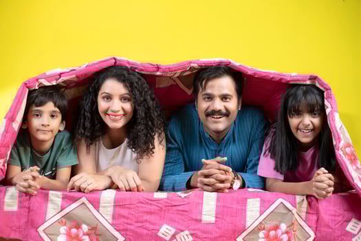 Playful Family With Children In Bed Under A Blanket photo