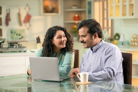 Happy Loving Couple Smiling While Looking At Laptop photo