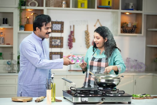 Romantic Husband Giving Wrapped Present To Happy Wife In Kitchen photo