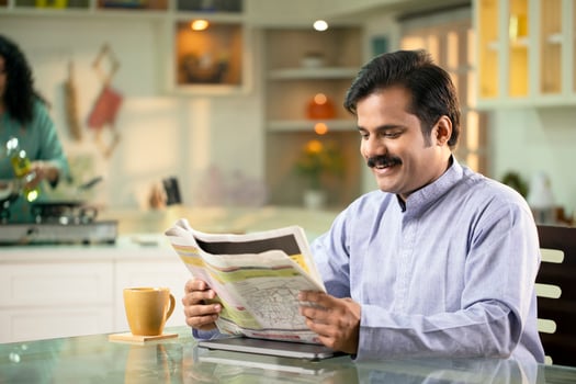 Man Reading Newspaper While Sitting At Home photo