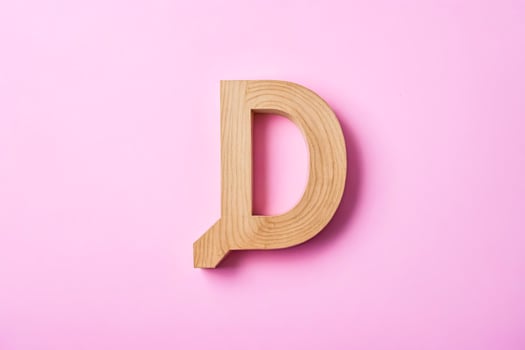 Wooden Letter D on Pink Background photo