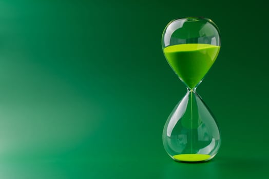 Hourglass standing still, working with time limit and limits, photo in studio on green background