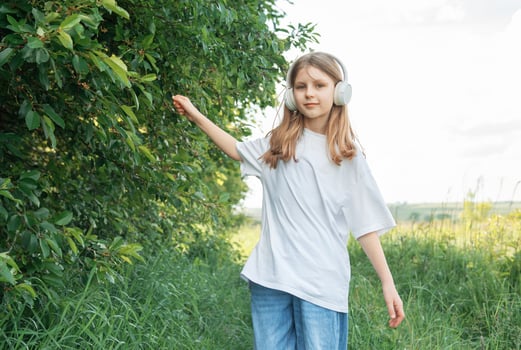 A child with headphones listening to music and dancing photo