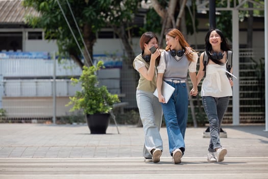 College friends walk to class together. University student in campus talk and have fun outdoors photo