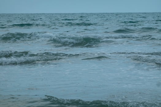 Ocean waves crash onto a sandy beach photo