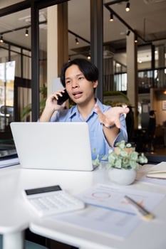 Business man asian discussing a new project with his client on the phone. business man working on a laptop in office photo