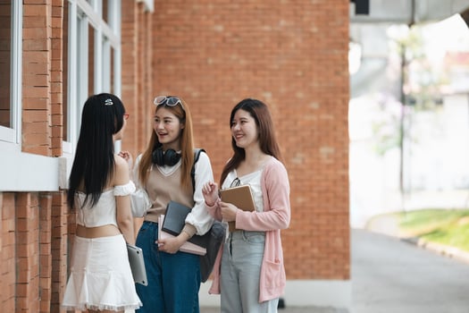 Students socializing outside a school building. Group of young friends talking and laughing on campus. Concept of education, friendship, and student life photo