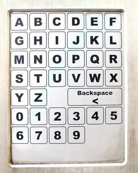 close up of a metal keypad number and alphabet on a public facility. unclean metal object photo
