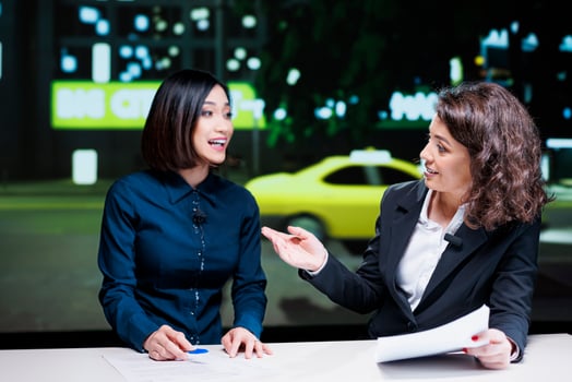 Diverse team reading latest headlines in newsroom, covering all important topics for international news channel. Women newscasters reporting celebrity scandals and creating content. photo