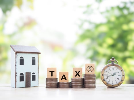 Vintage watch, Miniature house and Wooden blocks with the word TAX on stack of coins. The concept of payment tax for house, manage time to success, Property investment, House mortgage, Real estate photo