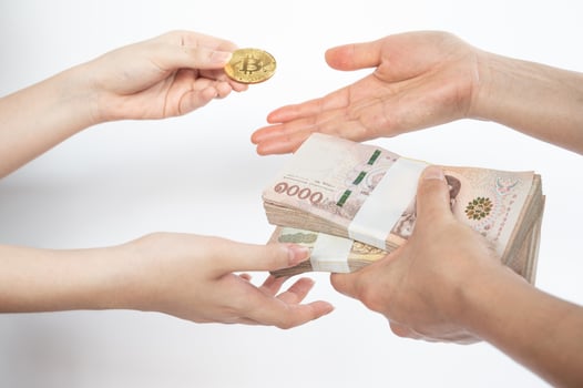 Cropped shot of people hands trading bitcoin token with Thai baht banknotes isolated on white background. Conceptual shot of financial and economic. photo
