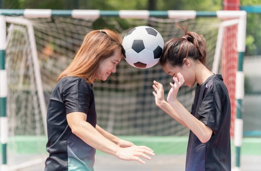 Mom with a child playing football in the urban outdoor futsal court photo