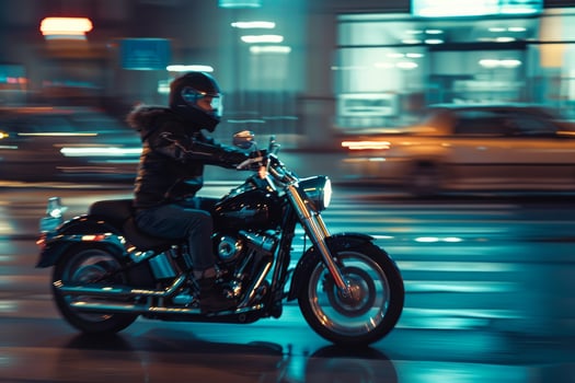 Biker is riding a motorcycle at night in the city with motion blur photo