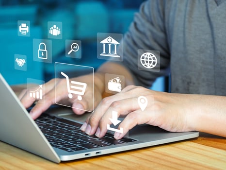 a person typing on a laptop with icons on the screen photo