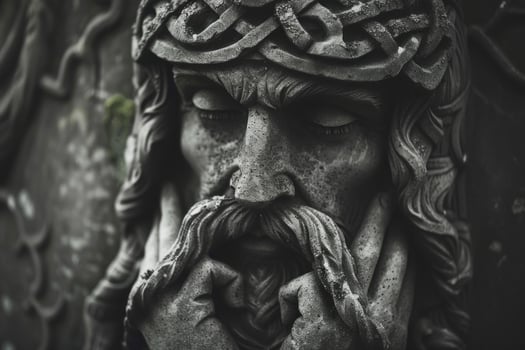 Ancient stone statue of jesus christ wearing crown of thorns photo