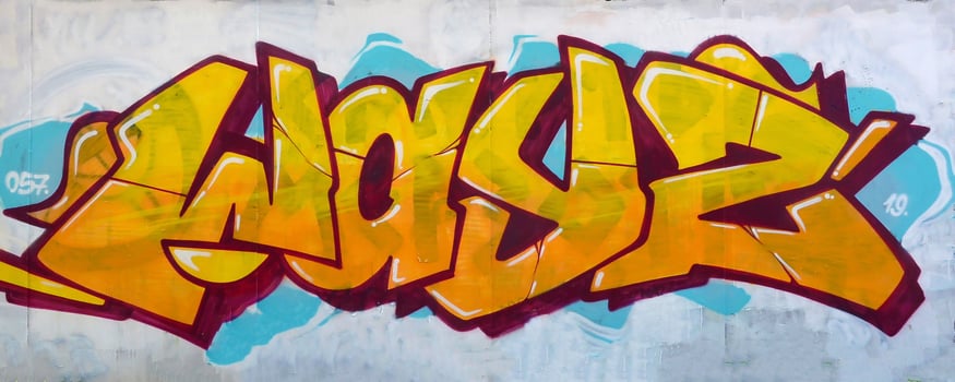 Colorful background of graffiti painting artwork with bright aerosol outlines on wall. Old school street art piece made with aerosol spray paint cans. Contemporary youth culture photo