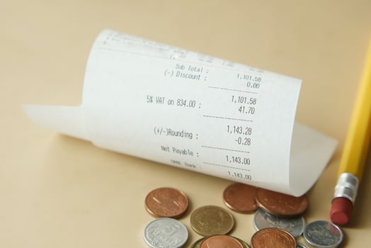 A receipt, coins, and a pencil on a table symbolize finance, transactions, and commerce photo