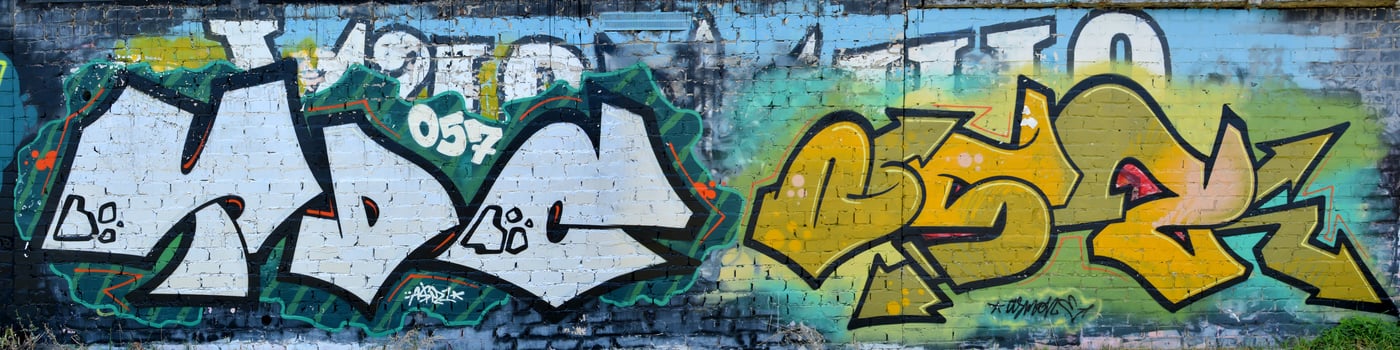 Colorful background of graffiti painting artwork with bright aerosol outlines on wall. Old school street art piece made with aerosol spray paint cans. Contemporary youth culture photo