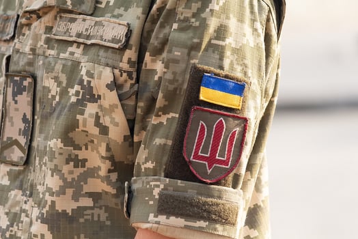 Ukrainian soldier in the army and flag, coat of arms with a golden trident on a military uniform background. Armed Forces of Ukraine photo