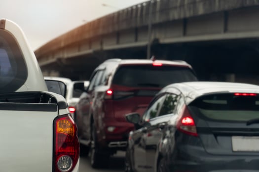 Rear side view of pickup car white color. Traffic jam on the road with cars in the city. Blurred background of concrete bridge. under white sky. photo