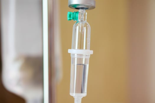 Close up medical intravenous IV drip in hospital background photo