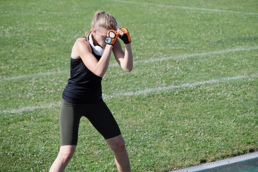 young female boxer training in the stadium standing in position photo