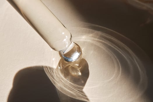 Pipette with serum on a beige background. photo