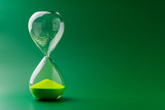 Hourglass standing still on green background, time concept and definition of oscillating period. photo