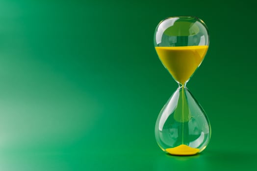 Hourglass standing still on green background, time concept and definition of oscillating period. photo
