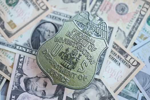 KYIV, UKRAINE - MARCH 9, 2024 US FBI Federal Bureau of Investigation badge on many US dollar bills photo