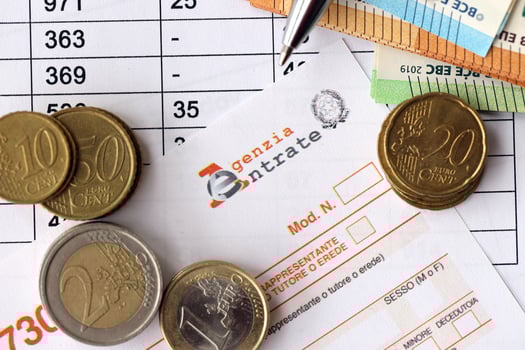 KYIV, UKRAINE - APRIL 20, 2024 Agenzia Entrate logo from blank tax form and many euro banknotes on office table photo