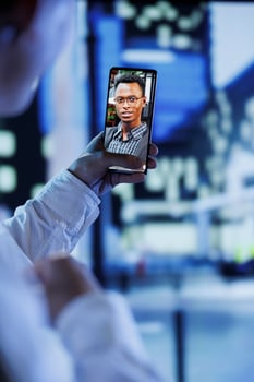 Woman in videocall with boyfriend while strolling around city streets at night, close up. Citizen using smartphone to show partner surroundings in dimly illuminated town center in blurry background photo