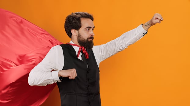 Powerful hero employee concept with cape preparing to serve clients at five star restaurant, working to help people with food orders. Strong confident butler with superhero red mantle. photo