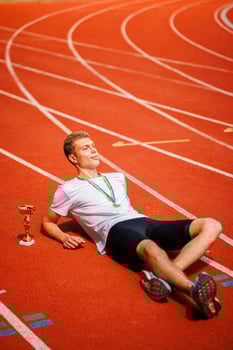 A track runner is standing at the starting line, getting ready for a quick sprint photo