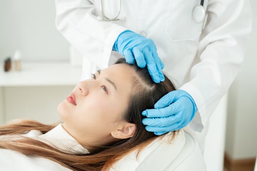 Specialist of hair recheck hair of Asian woman, damaged hair, hair loss, thinning problem, vitamin deficiency, baldness, postpartum, biotin, zinc, menstrual or endocrine disorders, hormonal imbalance photo