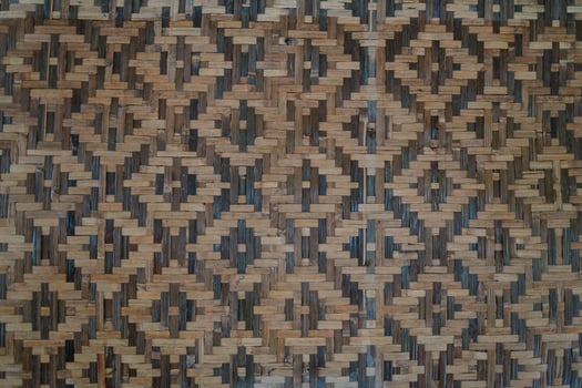 Wall made of woven bamboo in a square pattern, showcasing traditional craftsmanship and natural materials. photo