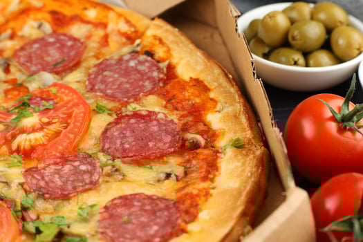 Pizza in a box on the table. Hot pizza with vegetables. Pizza in a restaurant. photo